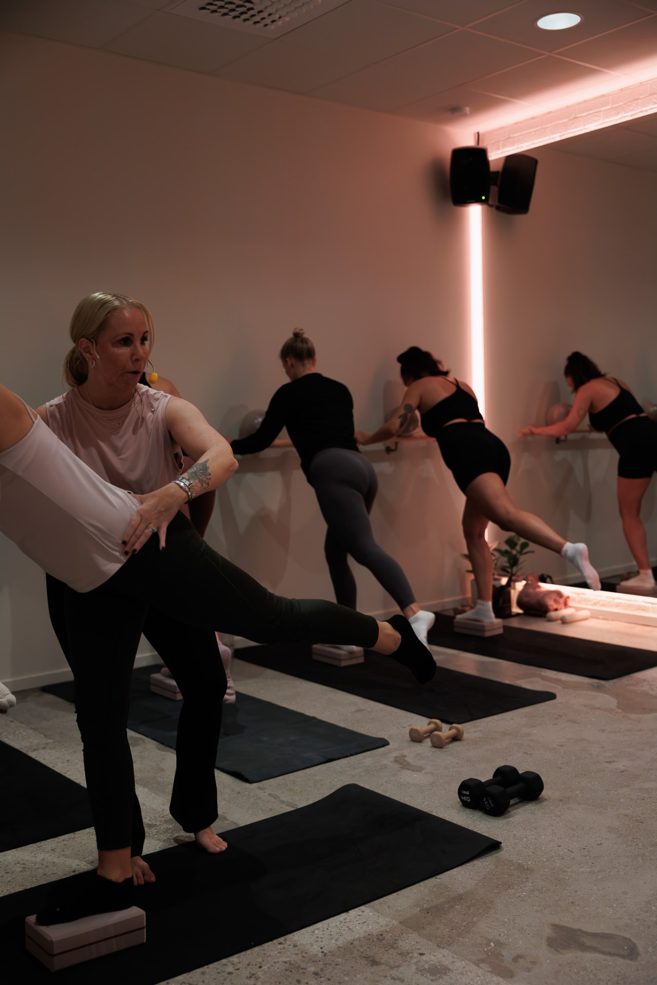 Instruktör och deltagare som tränar Barre vid barran på Core Pilates Studio i Visby